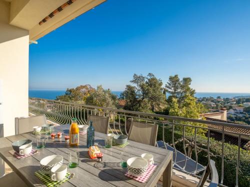 a table on a balcony with a view of the ocean at Holiday Home Gisele by Interhome in Saint-Aygulf