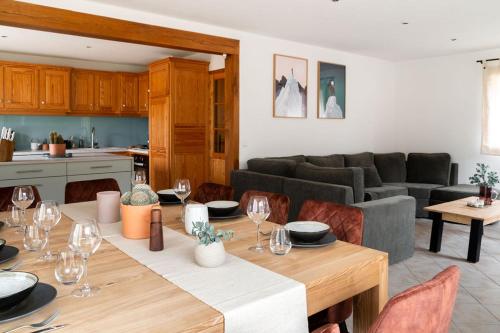 uma cozinha e uma sala de estar com uma mesa e copos de vinho em Chalet des bois de Criou em Morillon