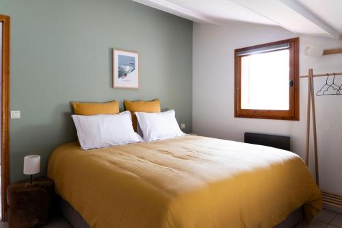 um quarto com uma cama grande e um cobertor amarelo em Chalet des bois de Criou em Morillon