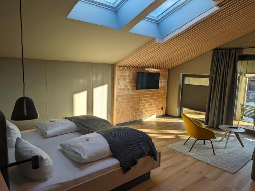 ein Schlafzimmer mit einem Bett und ein Zimmer mit einem TV in der Unterkunft Hotel Zum Goldenen Hirsch in Sonthofen