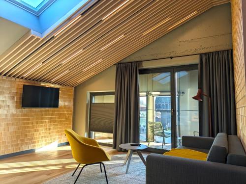ein Wohnzimmer mit einem Sofa und einem TV in der Unterkunft Hotel Zum Goldenen Hirsch in Sonthofen