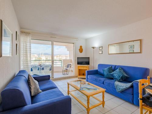 un salon avec un canapé bleu et une table dans l'établissement Apartment Le Borghese-2 by Interhome, à Fréjus