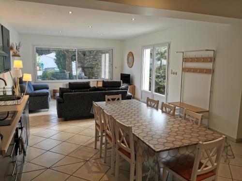 une cuisine et un salon avec une table et des chaises dans l'établissement La Roseraie a 1km de la plage, à Longeville-sur-Mer