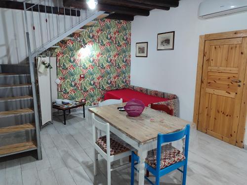 a table and chairs in a room with a staircase at A' casuzza in Palermo