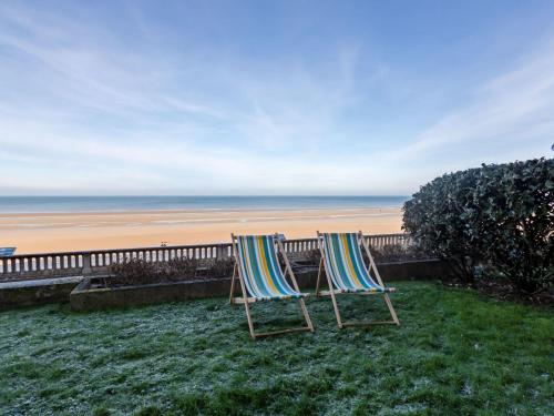2 chaises assises sur l'herbe près de la plage dans l'établissement Apartment Les Caravelles-5 by Interhome, à Cabourg