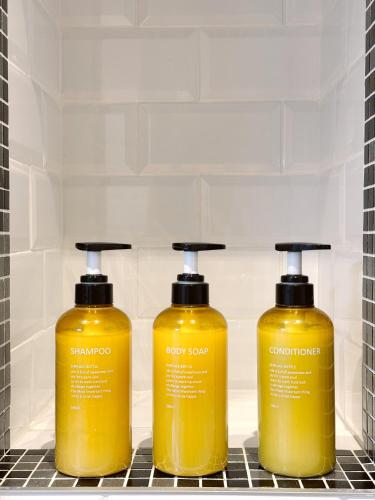 three bottles of yellow detergent sitting on a shelf at Modern City Centre Two Bedroom Windsor Apartment - Grand Central House in Gibraltar