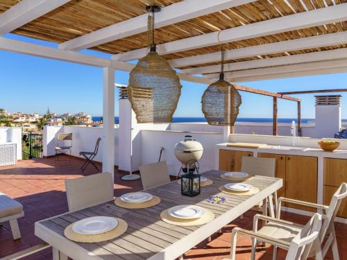 a dining room with a table and a view of the ocean at Apartment Angel Blanco by Interhome in La Cala de Mijas