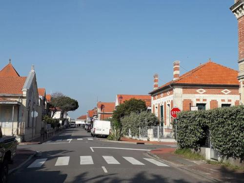 an empty street with a stop sign and houses at Maison centre ville - 7332 in Soulac-sur-Mer