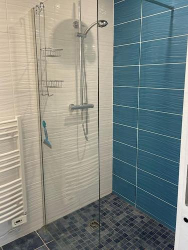 une douche avec une porte vitrée dans une salle de bain dans l'établissement Maison centre ville - 7332, à Soulac-sur-Mer