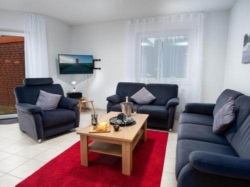 - un salon avec des canapés bleus et une table basse dans l'établissement Holiday Home Nilles by Interhome, à Norddeich