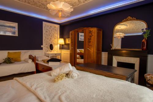 - une chambre avec 2 lits, une cheminée et un miroir dans l'établissement Cosy Art Gallery, à Reims