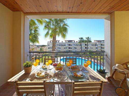 a table with food on a balcony with a palm tree at Apartment Vilas Mouriscas by Interhome in Vilamoura