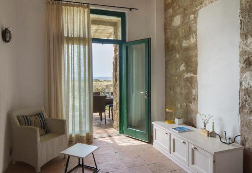 una sala de estar con una puerta que da a un balcón en Residenza A Cova, en Carloforte