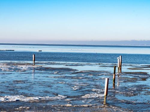 a large body of water with poles in the water at Holiday Home Reuse by Interhome in Norddeich