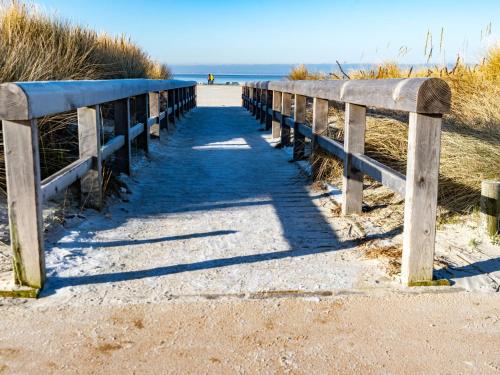 a wooden boardwalk leading to the beach at Holiday Home Reuse by Interhome in Norddeich