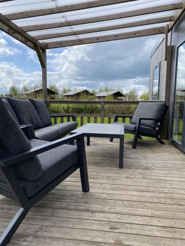 un patio avec deux chaises et une table sur une terrasse dans l'établissement Holiday Home Natuurlijk de Veenhoop by Interhome, à De Veenhoop