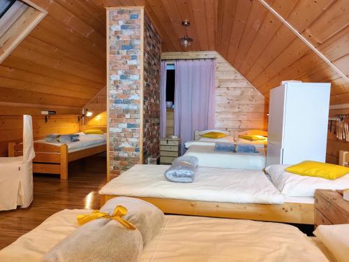 a room with two beds in a wooden house at Beskidzka Ostoja in Koszarawa
