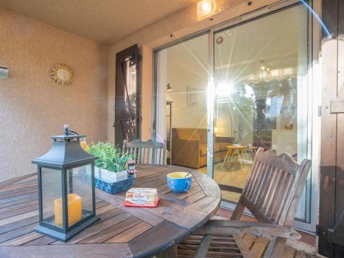 une table en bois avec une lampe sur la terrasse dans l'établissement Studio La Galiote-2 by Interhome, à Saint-Aygulf