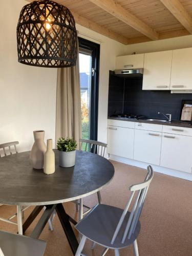 a kitchen and dining room with a table and chairs at Holiday Home 4-persoons Doutzen by Interhome in De Veenhoop