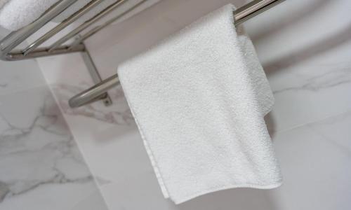 a white towel hanging on a towel rack in a bathroom at Hotel Crisol de las Rías in Miño