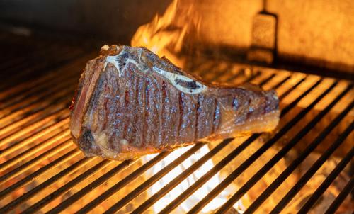 a piece of meat is cooking on a grill at Hotel Crisol de las Rías in Miño