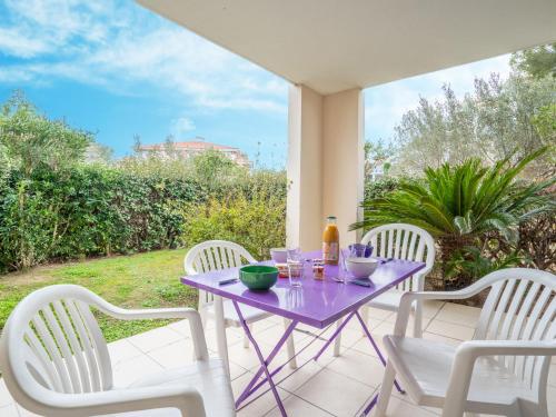 une table violette et quatre chaises sur une terrasse dans l'établissement Apartment Le Grand Parc-9 by Interhome, à Saint-Aygulf