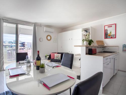 une cuisine et une salle à manger avec une table avec une bouteille de vin dans l'établissement Apartment Holidays 80 by Interhome, à Saint-Laurent-du-Var