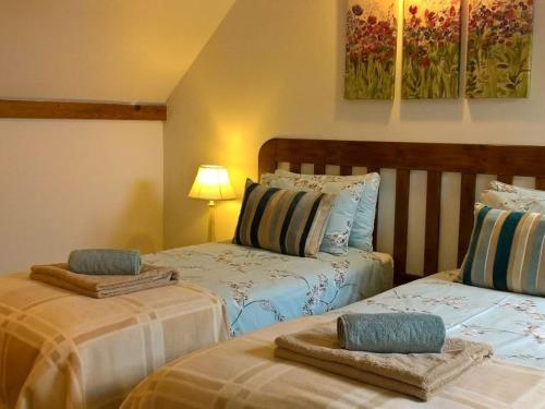 a bedroom with two beds with towels on them at WebberHillFarmCottages in Okehampton