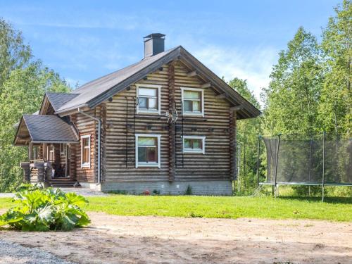 a wooden house with a fence in front of it at Holiday Home Täperän torppa by Interhome in Nilsiä