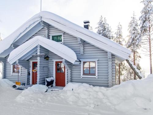 a house covered in snow with a red door at Holiday Home Hallan-etappi b paritalo by Interhome in Hyrynsalmi