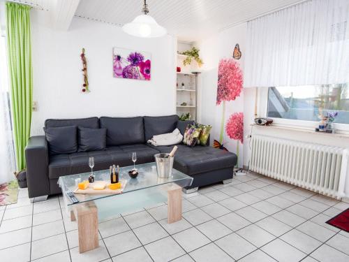 sala de estar con sofá negro y mesa en Apartment Knurrhahn by Interhome, en Norddeich