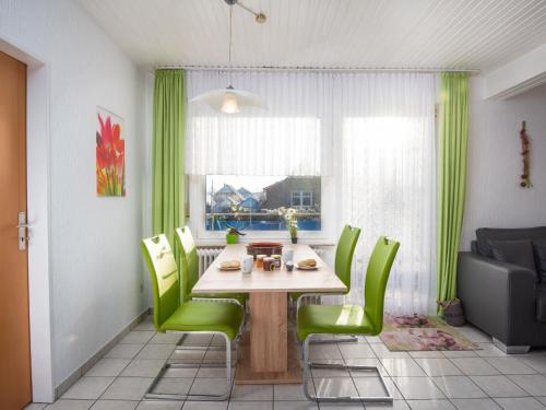 comedor con mesa y sillas verdes en Apartment Knurrhahn by Interhome, en Norddeich