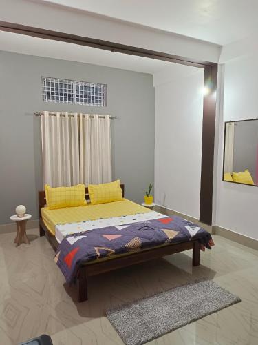 1 dormitorio con 1 cama con almohadas amarillas en Relaxing Oasis, en Tezpur