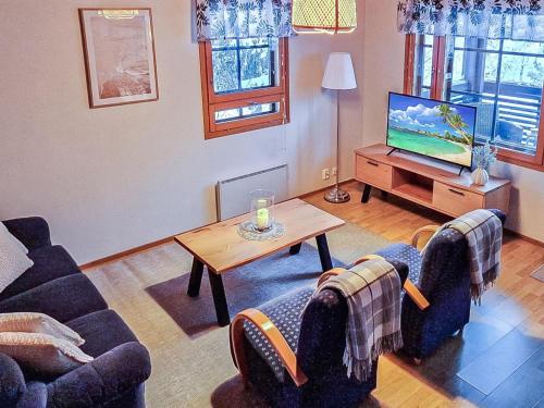 a living room with two couches and a tv at Holiday Home Alppitalo sinitähti 9 apt 3 by Interhome in Tahkovuori