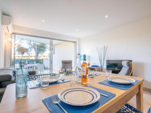 une table de salle à manger avec des assiettes et des verres dessus dans l'établissement Apartment Les Louvans-10 by Interhome, à Saint-Aygulf