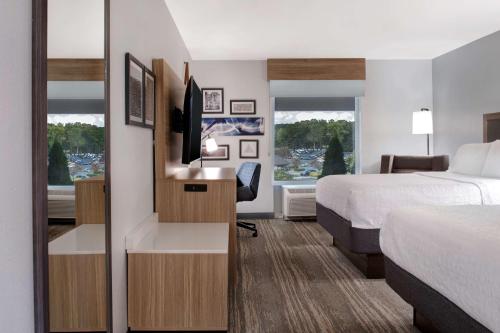 een hotelkamer met een bed en een bureau met een televisie bij Hampton Inn Easley in Easley