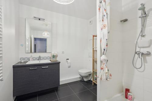 ein Badezimmer mit einem Waschbecken, einem WC und einem Spiegel in der Unterkunft Your home in Gentilly in Gentilly