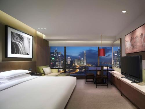香港にあるグランド ハイアット 香港の大型ベッドとテレビが備わるホテルルームです。