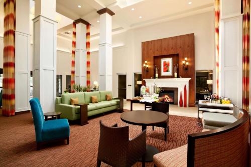 a living room with a couch and a fireplace at Hilton Garden Inn Rochester/Pittsford in Bushnell Basin