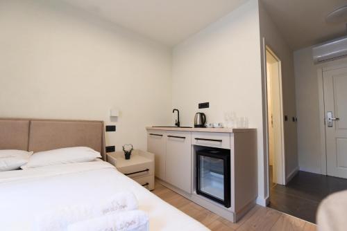a white bedroom with a bed and a fireplace at Iva Old Town in Belgrade