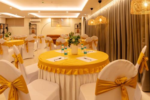 a banquet hall with tables and chairs with bows at Earth Hotels in Bengaluru