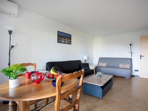 ein Wohnzimmer mit einem Tisch und einem Sofa in der Unterkunft Studio Tivoli des Anges by Interhome in Villeneuve-Loubet