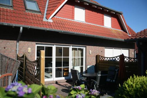 Un patio con una mesa y sillas frente a una casa. en Ferienhaus Schulte, en Carolinensiel
