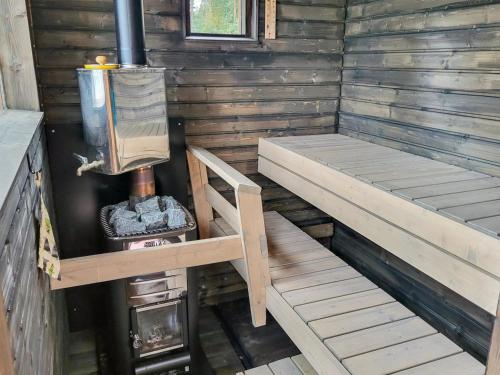 an inside of a wooden cabin with a stove at Holiday Home Kolin kangastus metsätähti 2 by Interhome in Kolinkylä