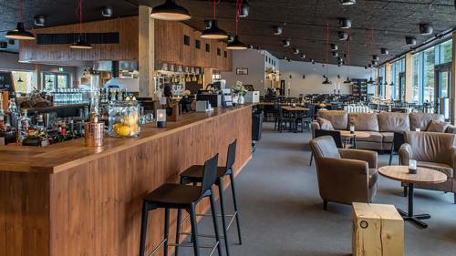 a bar in a restaurant with tables and chairs at Alpstigen 6A - 10 bäddars fjällstuga mitt i Järvsöbacken in Järvsö