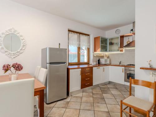 a kitchen with white cabinets and a stainless steel refrigerator at Holiday Home Mina by Interhome in Carriola