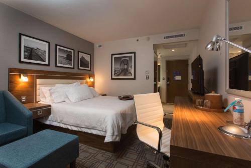 a hotel room with a bed and a living room at Hampton Inn by Hilton Hermosillo in Hermosillo