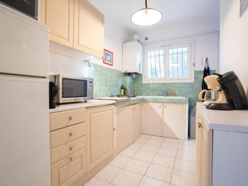 une cuisine avec un réfrigérateur et un micro-ondes dans l'établissement Apartment Le Darling by Interhome, à Saint-Aygulf