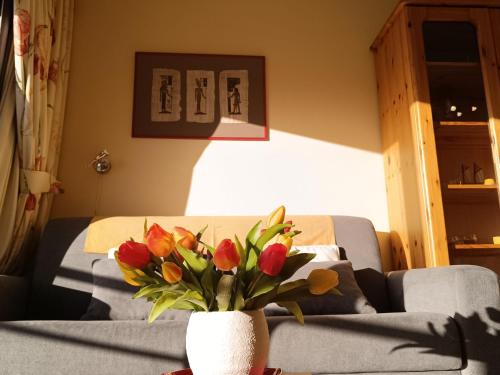 een vaas met bloemen op een tafel in een woonkamer bij Studio Green Garden-4 by Interhome in De Haan