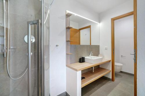 een badkamer met een wastafel en een douche bij Dahoam - Apartment Relaxsuite in Schenna